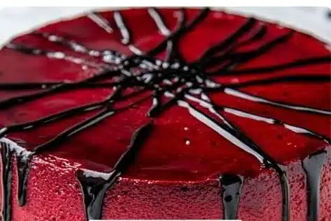 A Red Velvet Cheesecake with Chocolate Drizzle on Top and the Words Easy Simple Vampire Bite Red