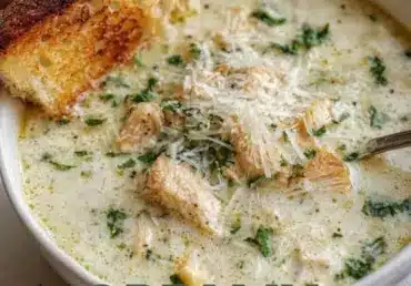 A bowl of creamy Garlic Parmesan Chicken Chowder garnished with parsley.