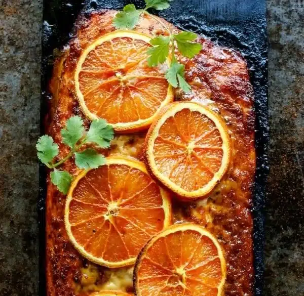 Grilled orange salmon with grape glaze and vibrant colors on a plate