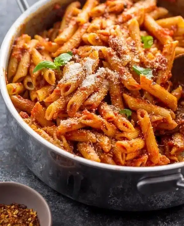 Savor pasta with a delicious sauce and parmesan | Penne pasta being added to sauce, pan of pasta with tomato sauce and basil, Italian food