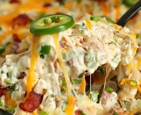 Delicious jalapeno popper casserole topped with cheese and jalapenos.